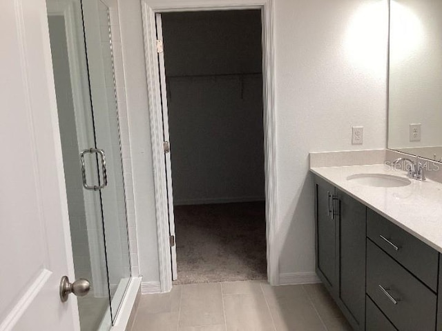 bathroom featuring tile patterned floors, an enclosed shower, and vanity