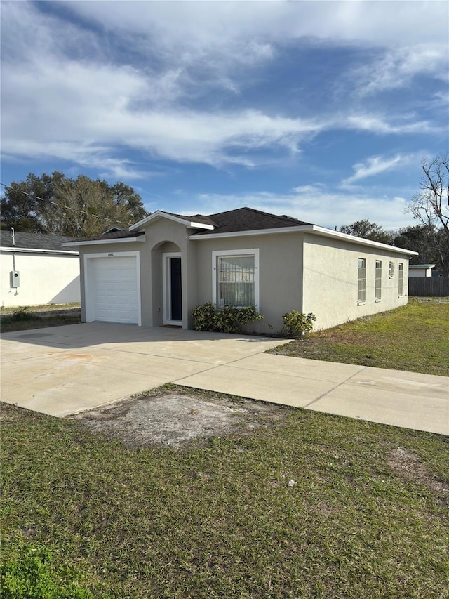 ranch-style house featuring a garage and a front lawn