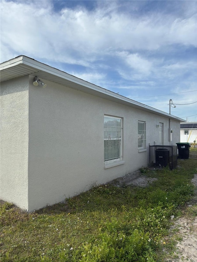 view of home's exterior with cooling unit and a lawn