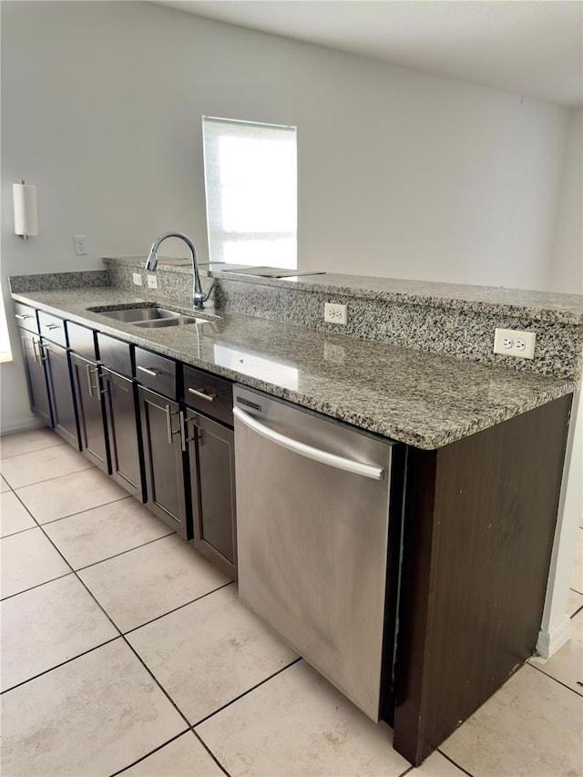 kitchen featuring light stone counters, dishwasher, sink, and dark brown cabinets