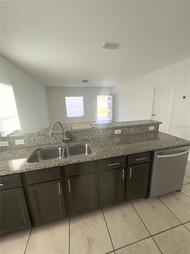 kitchen with dishwasher, sink, and dark stone counters