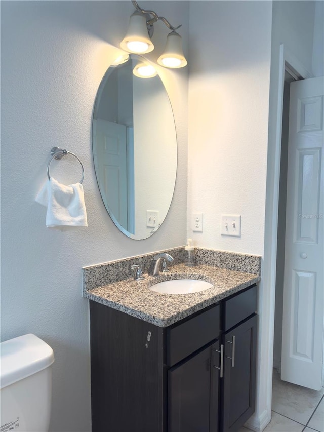 bathroom with vanity, tile patterned floors, and toilet