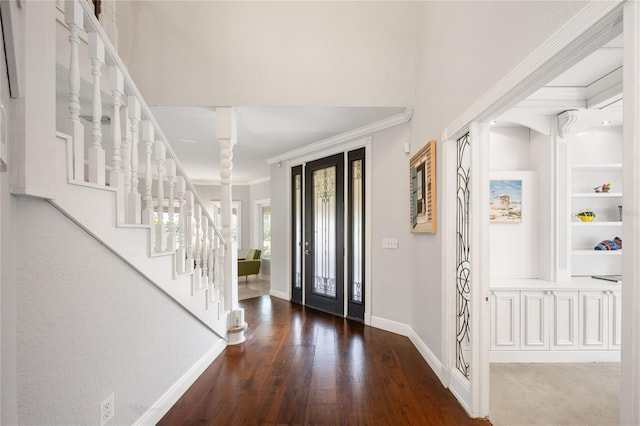 foyer with decorative columns, ornamental molding, and dark hardwood / wood-style floors