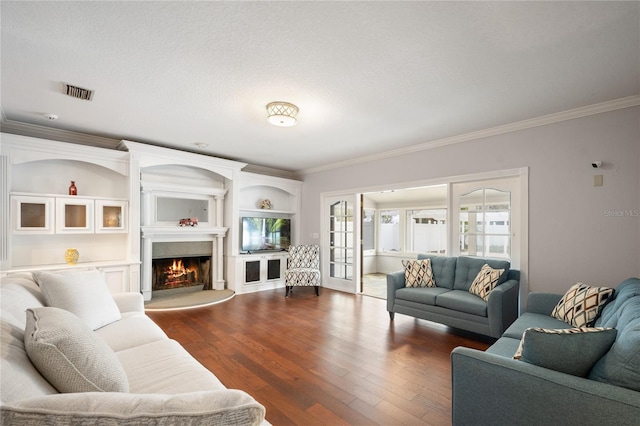 living room featuring crown molding, dark hardwood / wood-style flooring, and built in features