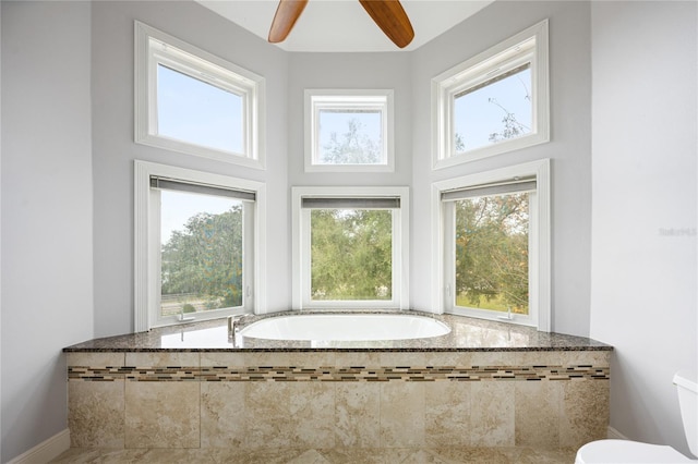 bathroom featuring toilet, a wealth of natural light, and tiled bath