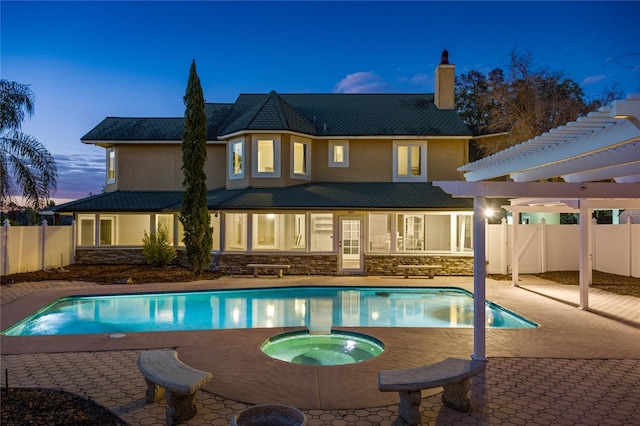 exterior space with a swimming pool with hot tub, a pergola, and a patio area