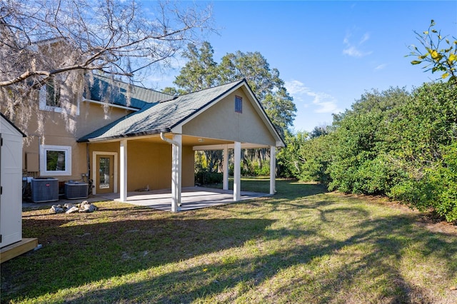 back of property featuring a patio, central AC, and a lawn