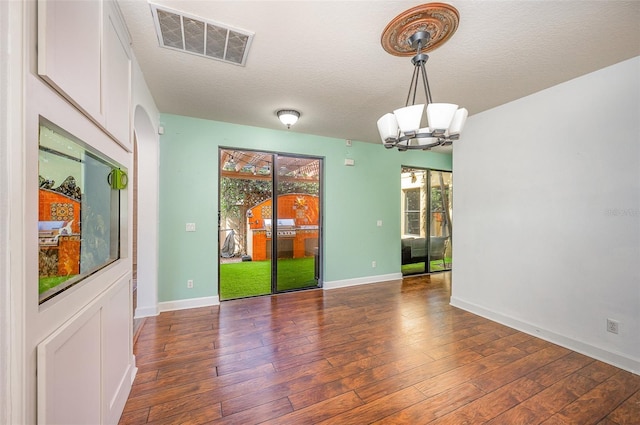 interior space featuring dark hardwood / wood-style flooring, a textured ceiling, and a chandelier