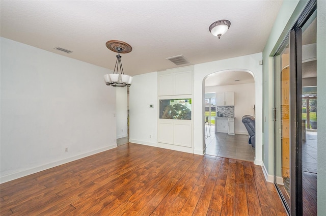 entryway with dark hardwood / wood-style flooring, a textured ceiling, and a chandelier