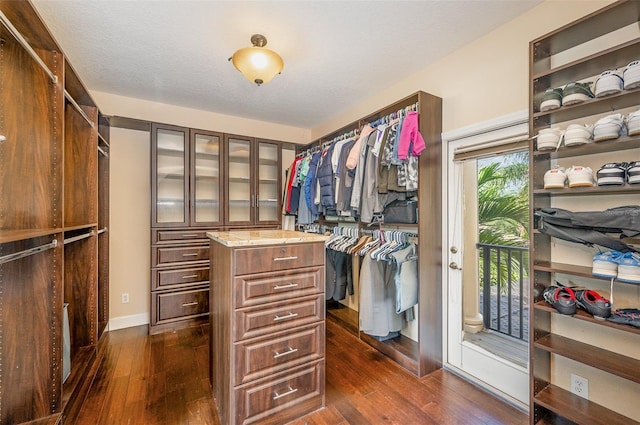 walk in closet with dark hardwood / wood-style floors