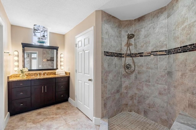 bathroom featuring tiled shower and vanity