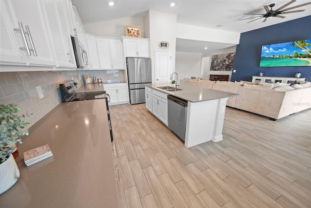 kitchen featuring appliances with stainless steel finishes, white cabinetry, sink, a center island with sink, and light hardwood / wood-style flooring