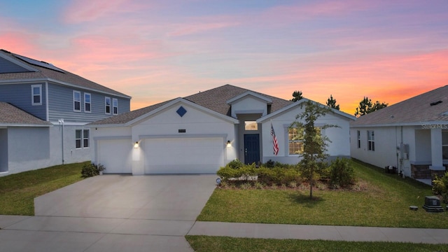 view of front of house with a yard and a garage