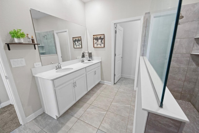 bathroom with tiled shower, vanity, and tile patterned flooring