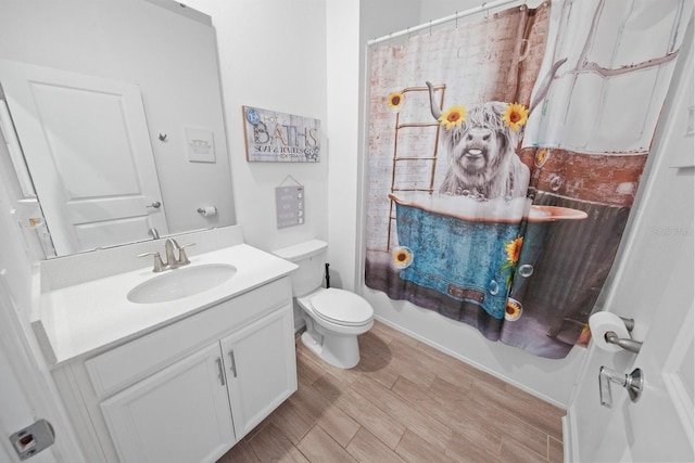 bathroom with a shower with curtain, wood-type flooring, toilet, and vanity