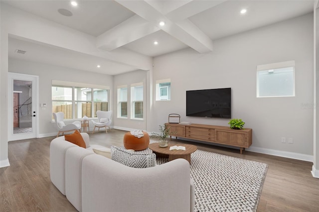 living room with beamed ceiling and light wood-type flooring