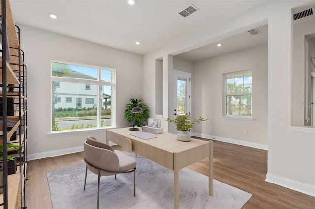 home office featuring a healthy amount of sunlight and dark hardwood / wood-style floors