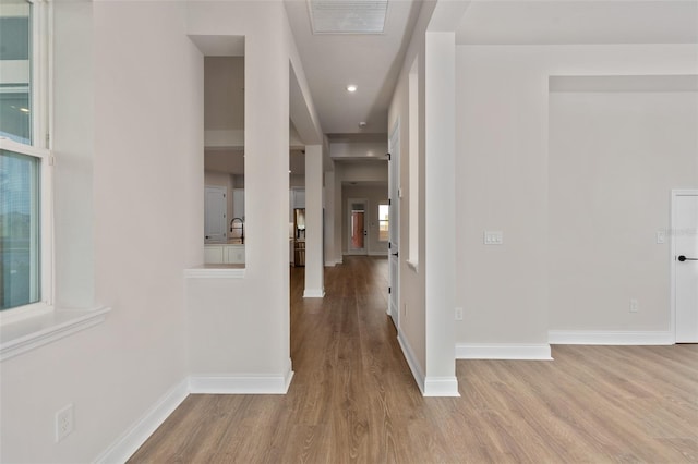 hall with sink and light hardwood / wood-style floors