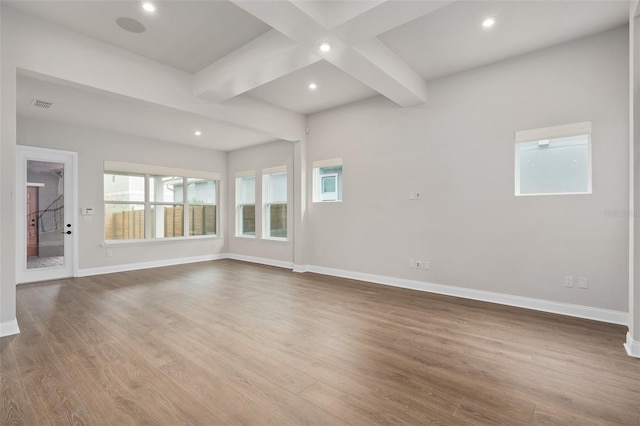 unfurnished living room featuring wood-type flooring and beamed ceiling