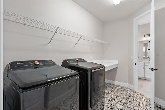 laundry area with separate washer and dryer and light tile patterned floors