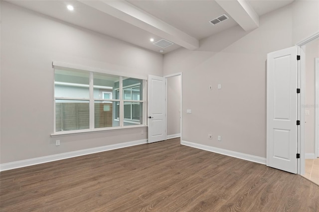 empty room featuring dark hardwood / wood-style floors and beamed ceiling