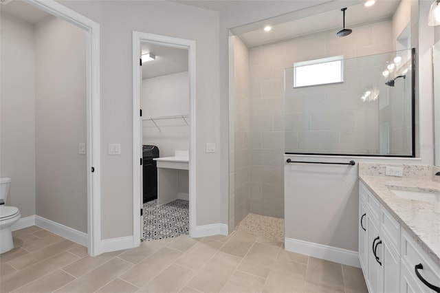 bathroom featuring vanity, toilet, and tiled shower