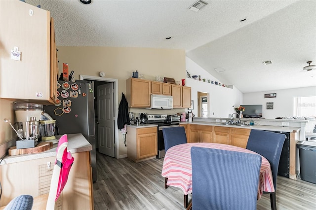 kitchen with lofted ceiling, sink, stainless steel electric range, kitchen peninsula, and hardwood / wood-style flooring