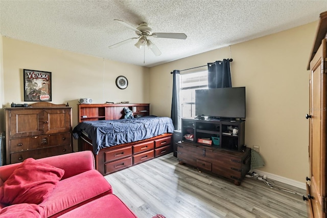 bedroom featuring a textured ceiling, ceiling fan, and light wood-type flooring