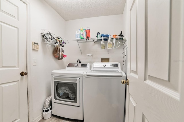 washroom featuring washer and clothes dryer and a textured ceiling