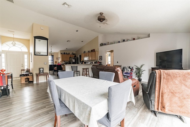 dining space featuring lofted ceiling and light wood-type flooring