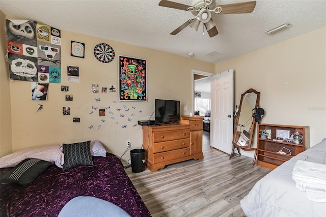 bedroom featuring a textured ceiling, ceiling fan, and light hardwood / wood-style flooring