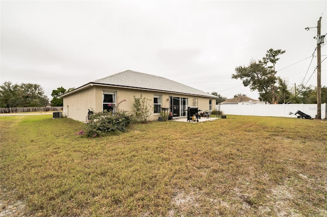 rear view of house with a yard and a patio