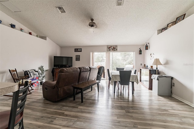 living room featuring wood-type flooring and a textured ceiling