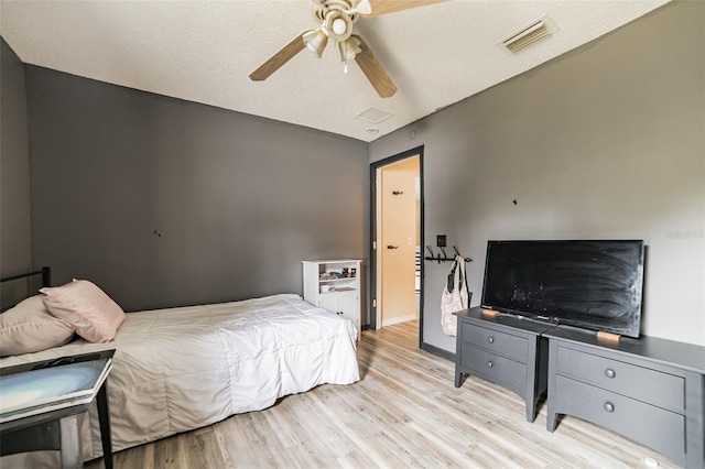 bedroom featuring a textured ceiling, ceiling fan, and light hardwood / wood-style flooring