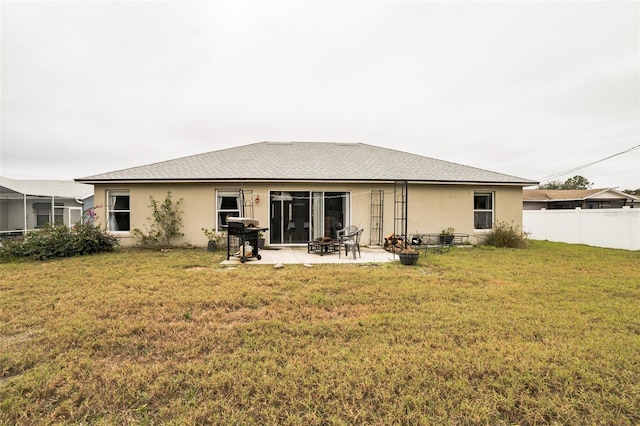 back of house with a patio and a lawn