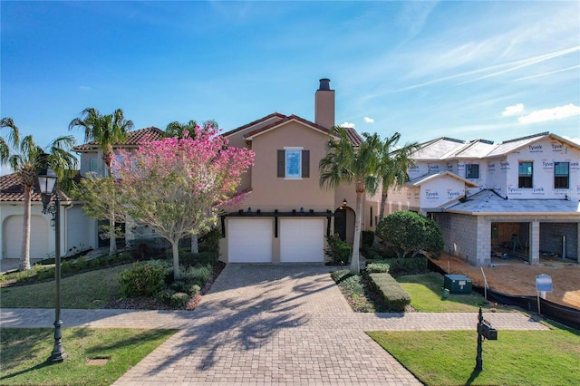 mediterranean / spanish house featuring a garage and a front yard