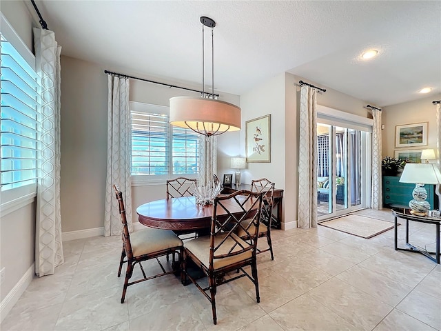 dining room with a textured ceiling and light tile patterned floors