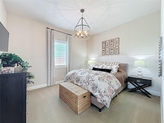 bedroom featuring light carpet and an inviting chandelier