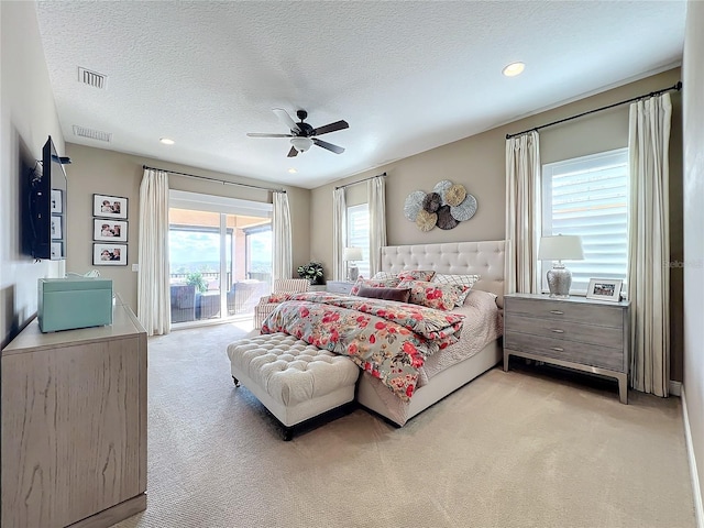 carpeted bedroom featuring ceiling fan, access to outside, and a textured ceiling