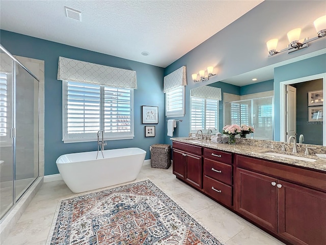 bathroom with vanity, shower with separate bathtub, and a textured ceiling