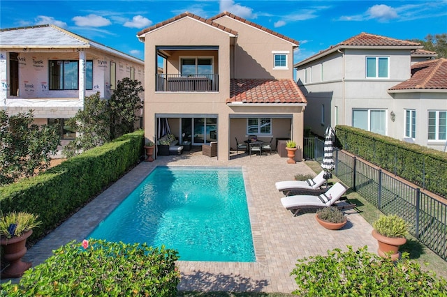 rear view of house with a fenced in pool, a patio, and an outdoor hangout area