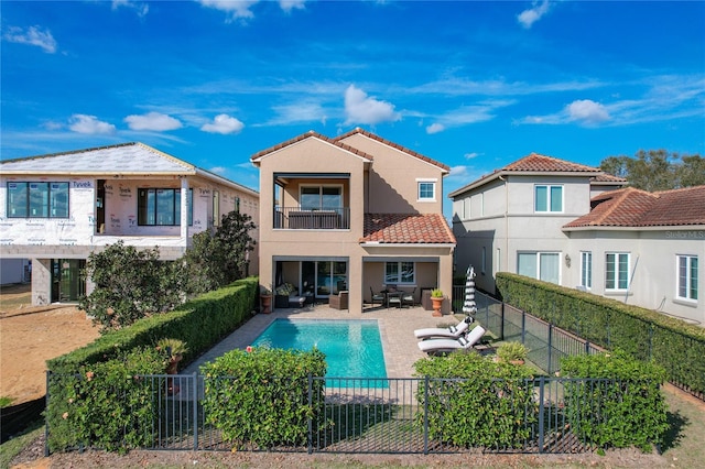 rear view of house featuring a fenced in pool, a patio area, outdoor lounge area, and a balcony