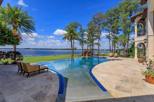 outdoor pool featuring a patio, a lawn, and a water view