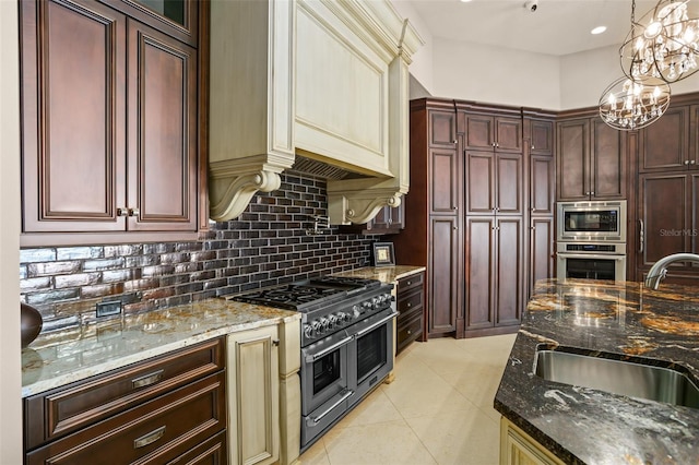 kitchen featuring tasteful backsplash, stainless steel appliances, dark stone counters, and a sink