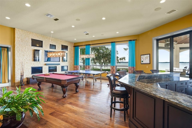 recreation room with recessed lighting, visible vents, and wood finished floors