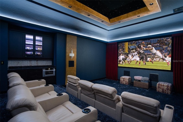 home theater with a tray ceiling and visible vents