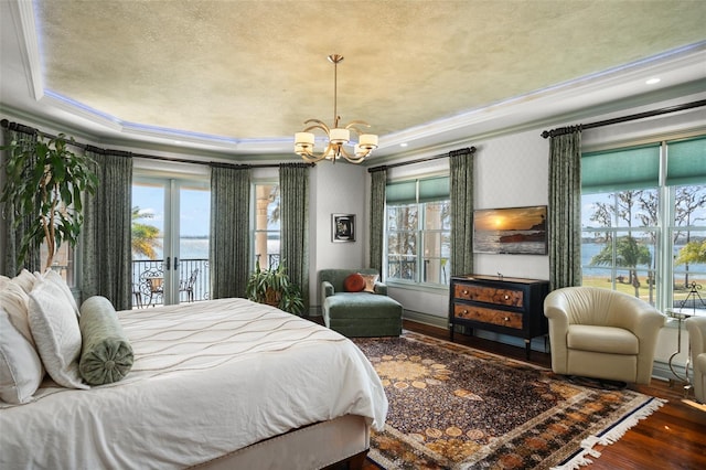 bedroom featuring multiple windows, an inviting chandelier, wood finished floors, and ornamental molding