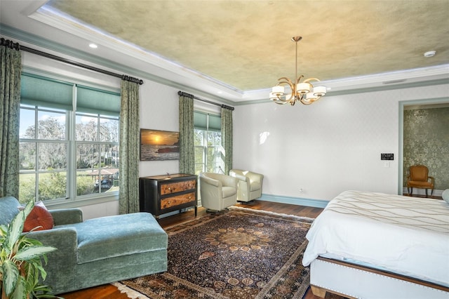 bedroom with a notable chandelier, wood finished floors, and ornamental molding