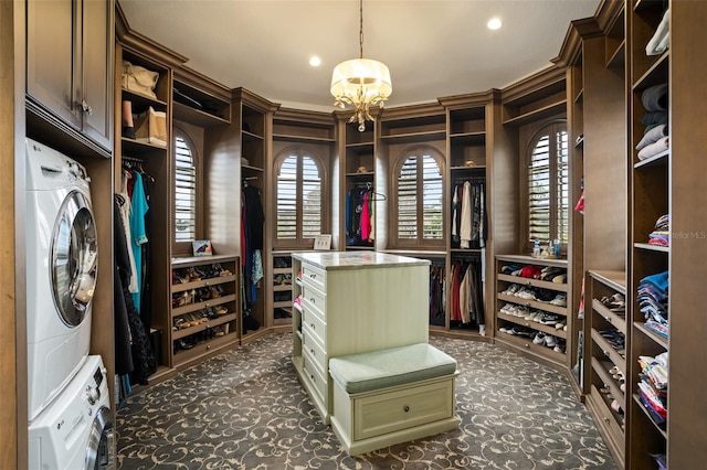 spacious closet with dark carpet and stacked washer and dryer