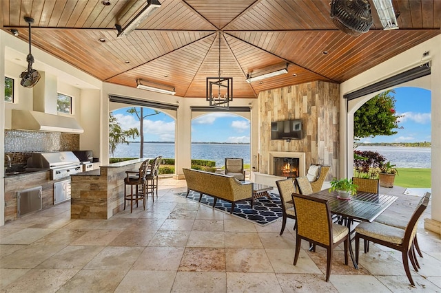 view of patio / terrace featuring outdoor dining space, area for grilling, a fireplace, and a grill